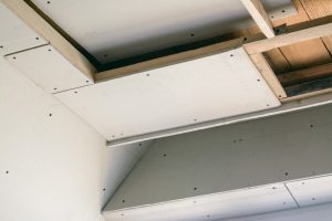 Construction room with drywall. Making suspended ceiling using wooden frame and drywall in a private house